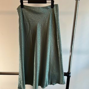 Green women’s skirt. Size Large. Never worn. Satin-like finish. Side zipper.